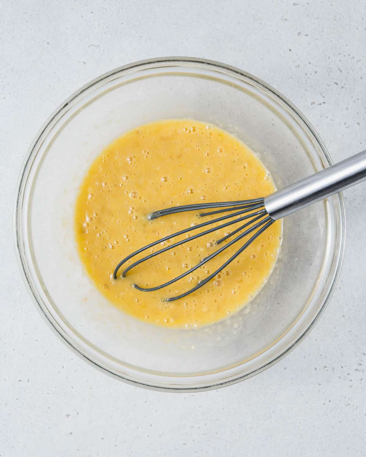 Banana and egg mixture in a bowl.