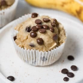 a single banana muffins on a plate topped with chocolate chips.