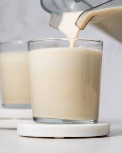 Pouring protein shake into a cup.