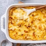Mac and cheese with cauliflower in a white dish with spoon in the dish.
