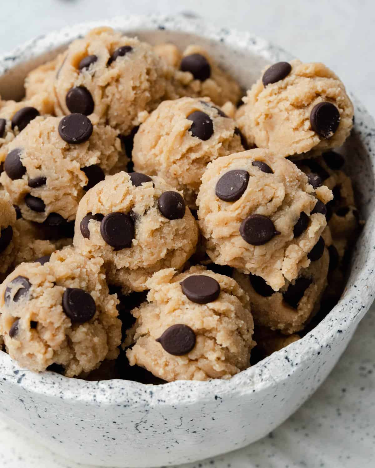 balls of edible protein cookie dough in a speckled white bowl