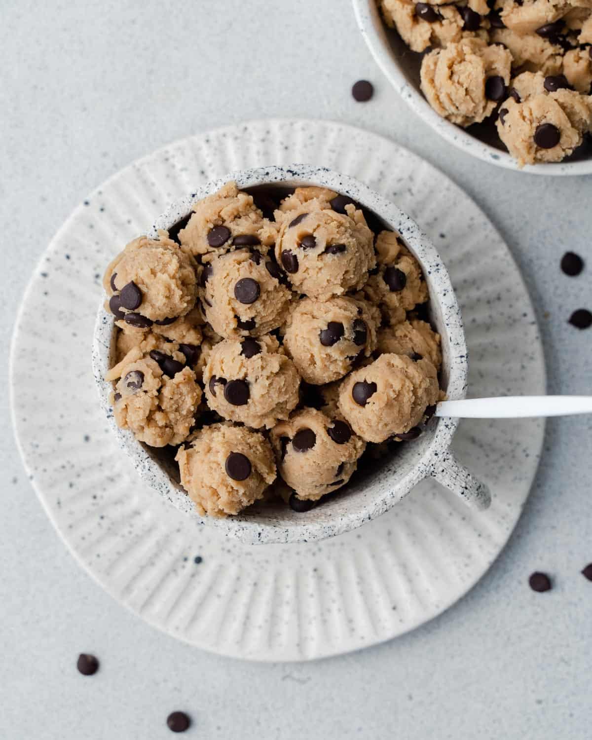 edible chocolate chip cookie dough in a white bowl on a plate