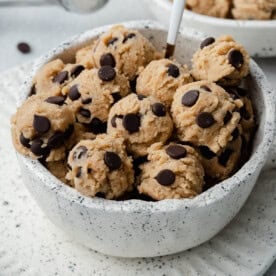 edible cookie dough balls in a white bowl.