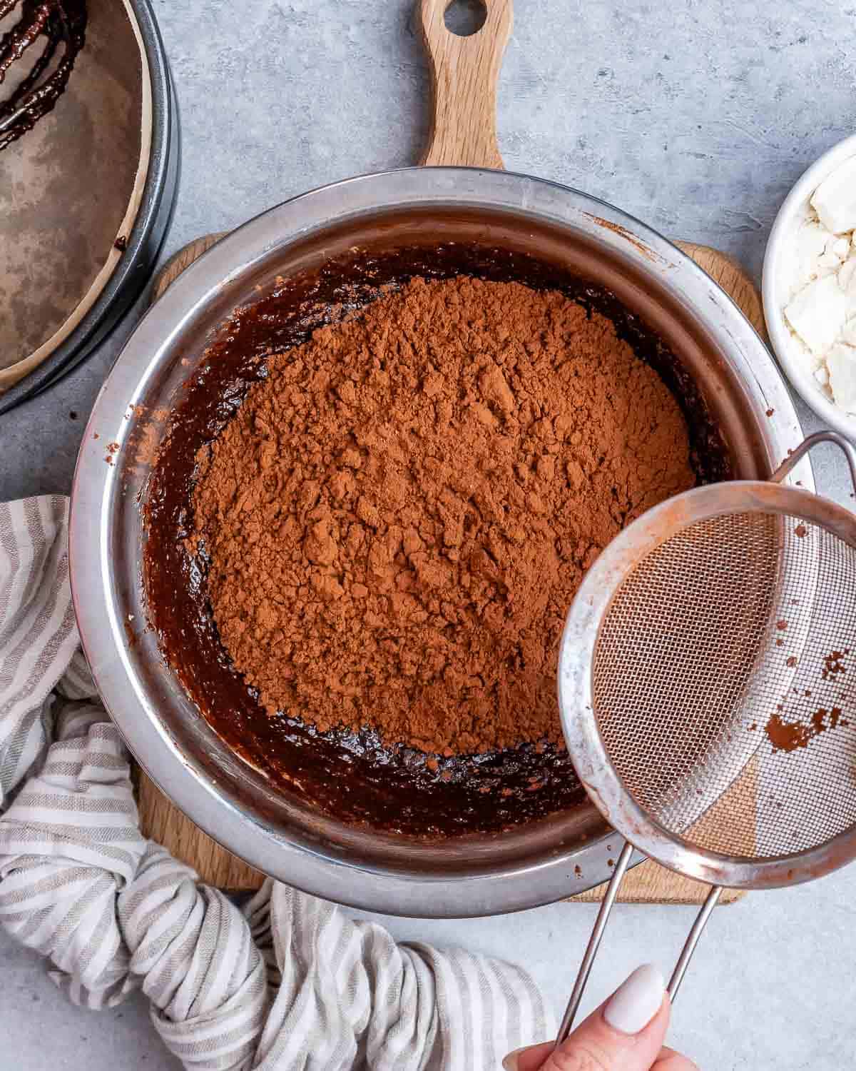 A sifter next to a large bowl with chocolate powder.