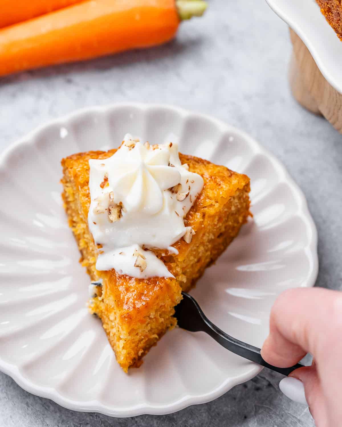 A fork taking a piece out of a slice of cake.