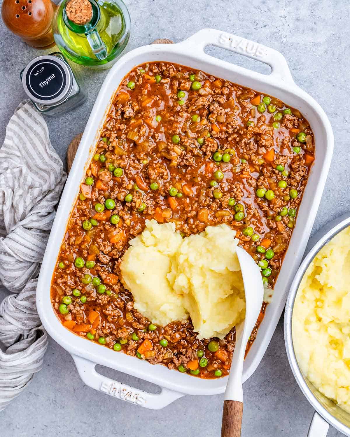 A white casserole dish. with a dollop of potatoes on top.