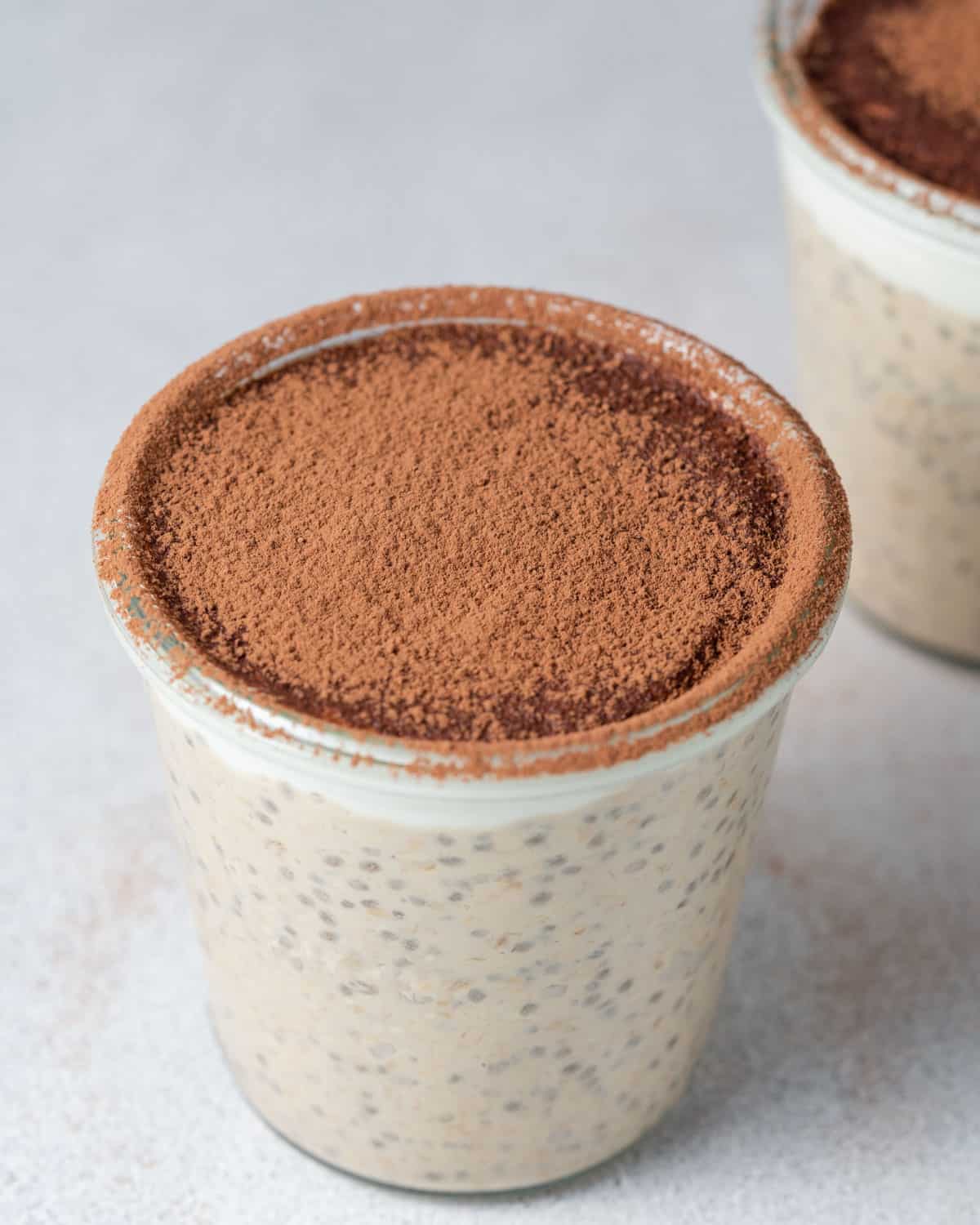 a jar with overnight oats topped with cocoa powder.