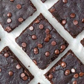 brownies on a parchment paper topped with chocolate chips.