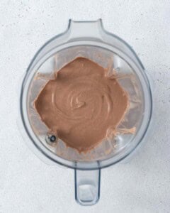 Blended chocolate mousse inside a blender jar with visible swirls of creaminess.