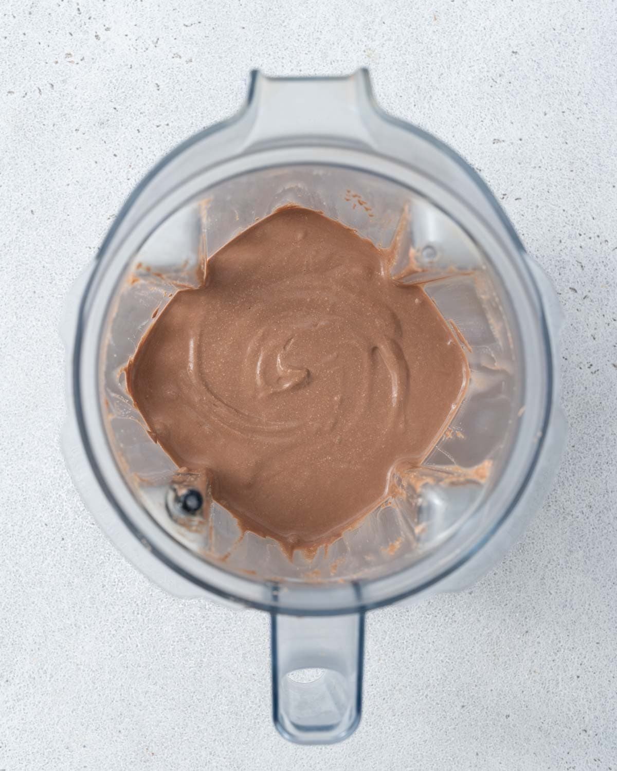 Blended chocolate mousse inside a blender jar with visible swirls of creaminess.