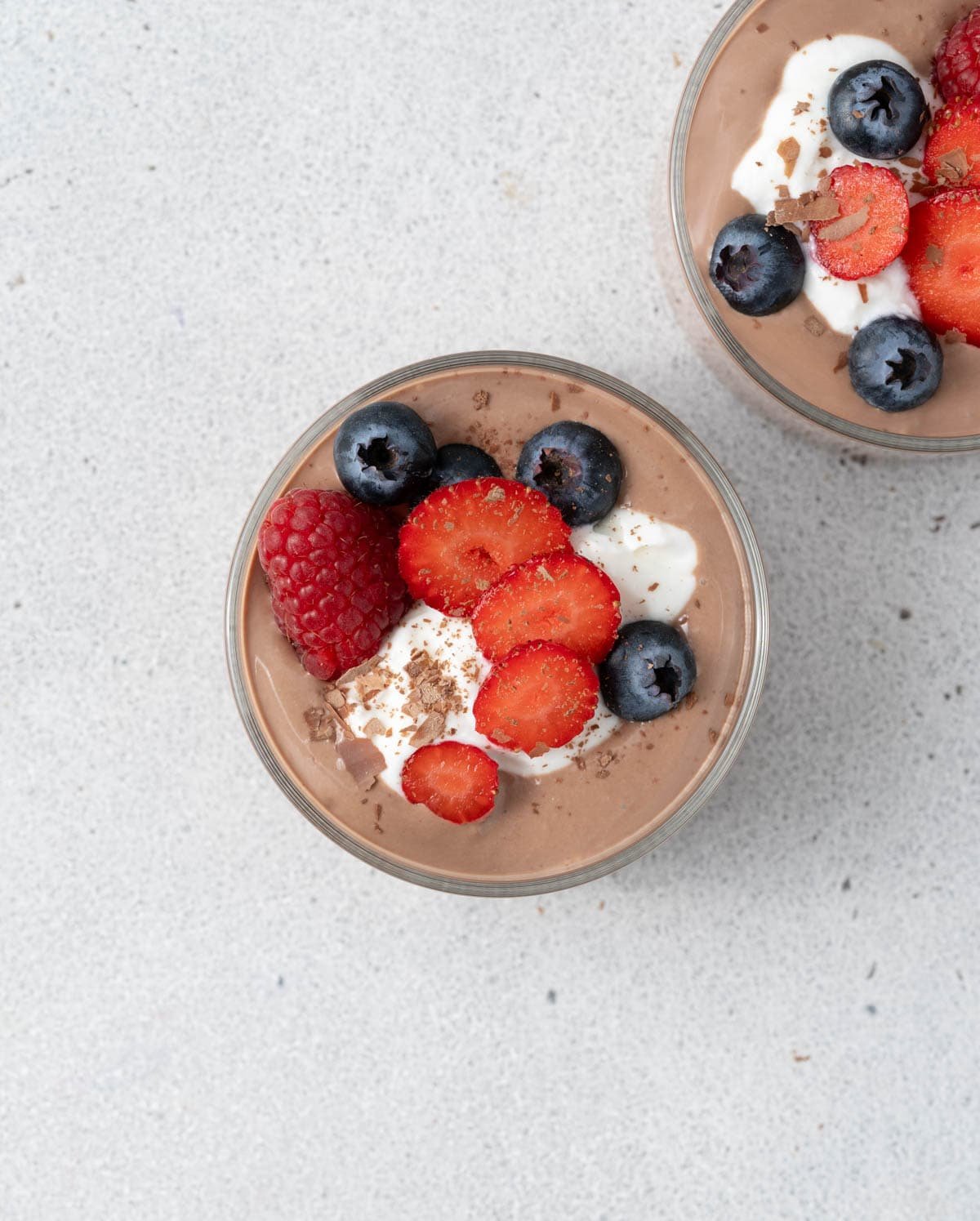 Two small bowls of chocolate on a white surface