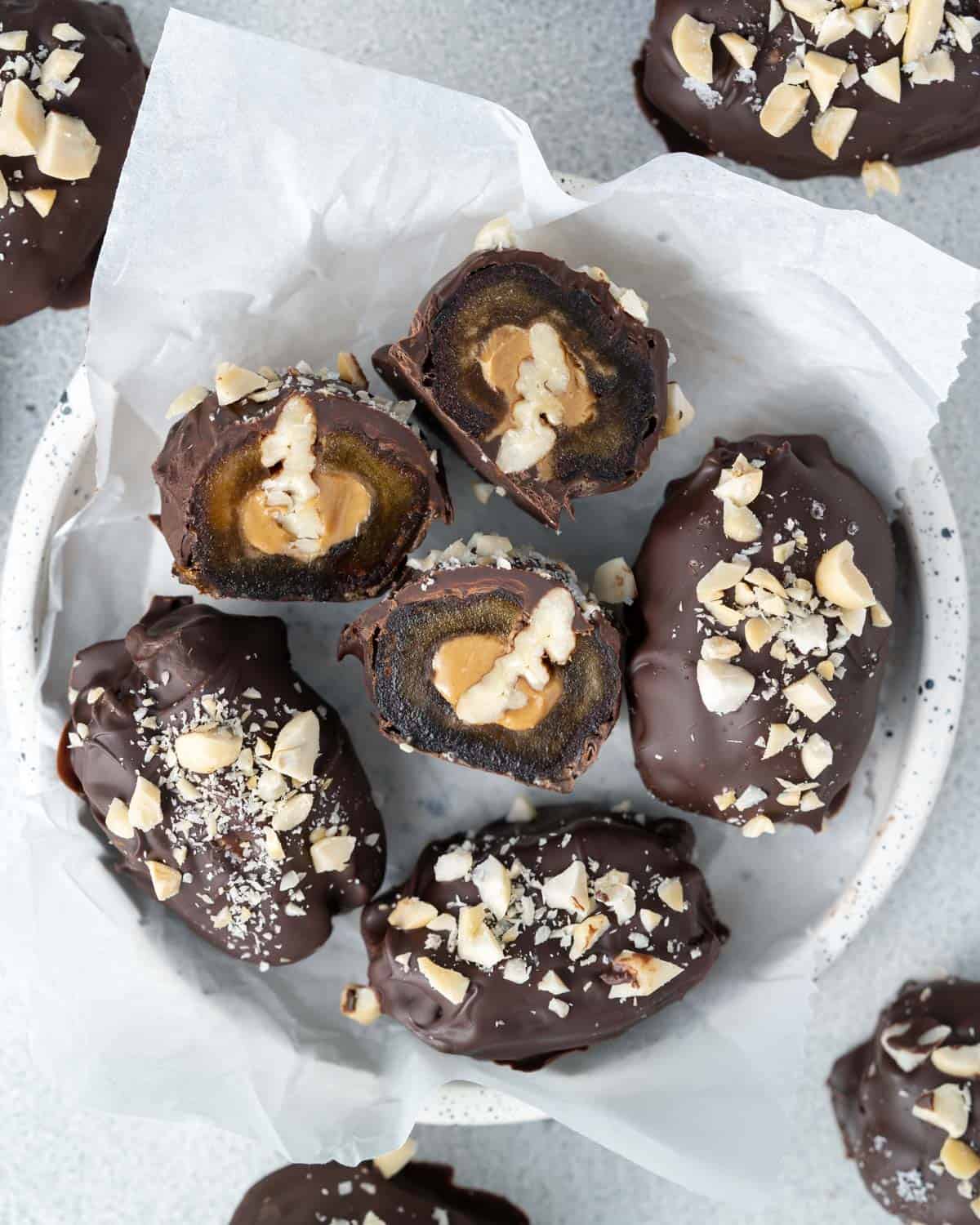 A close-up overhead shot of sliced date Snickers showing peanut butter and pecan filling inside the chocolate coating.