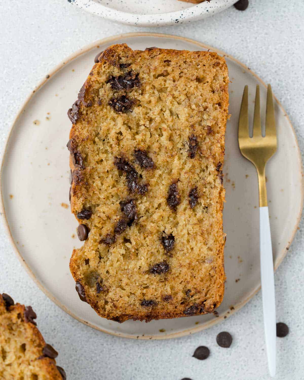 a slice of banana bread on a plate with a fork next to it. 