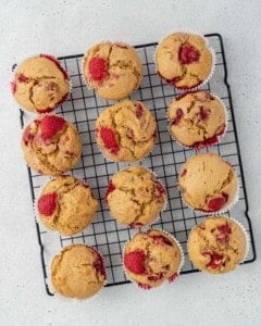 Raspberry muffins on a wire rack to be cooled.