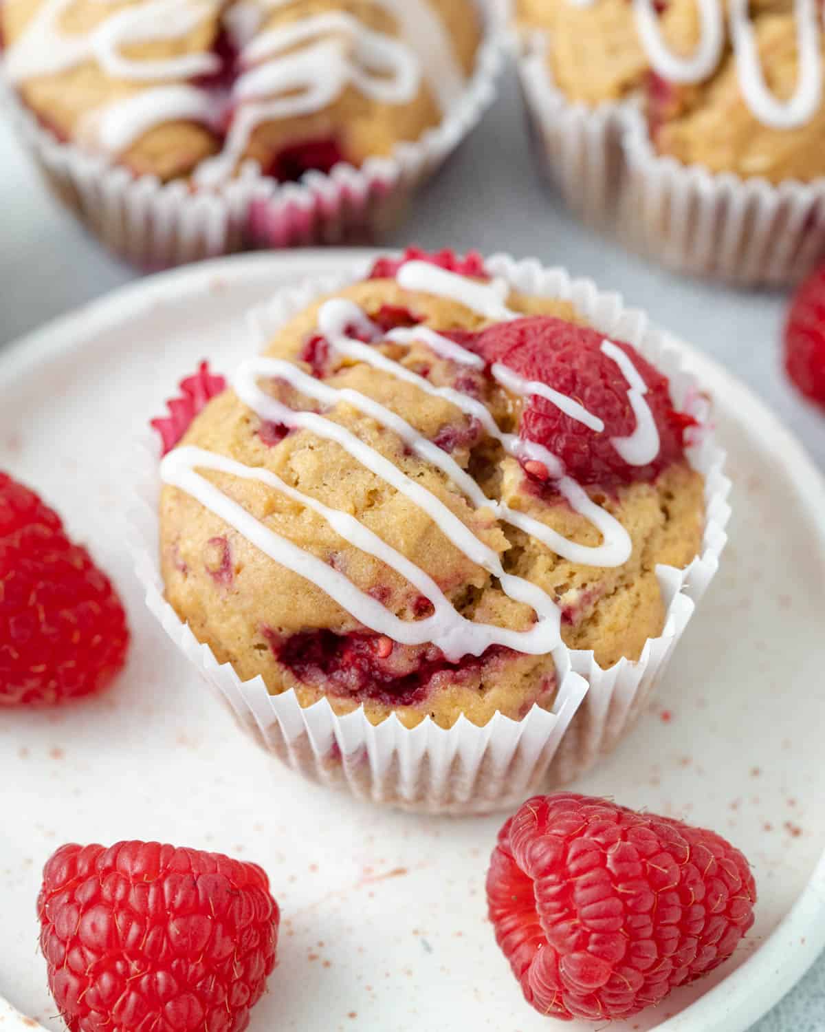 muffin on a plate with sugar glaze added over it.