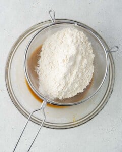 Flour being powdered over the wet egg mixture.