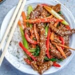 a round bowl filled with rice topped with mongolian beef stir fry.