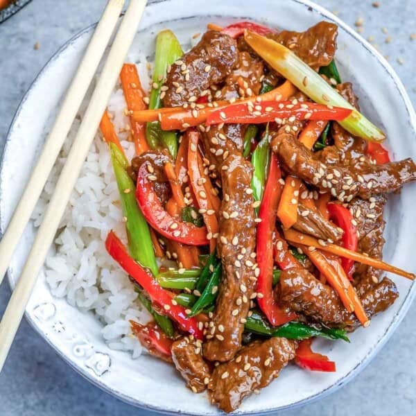 a round bowl filled with rice topped with mongolian beef stir fry.