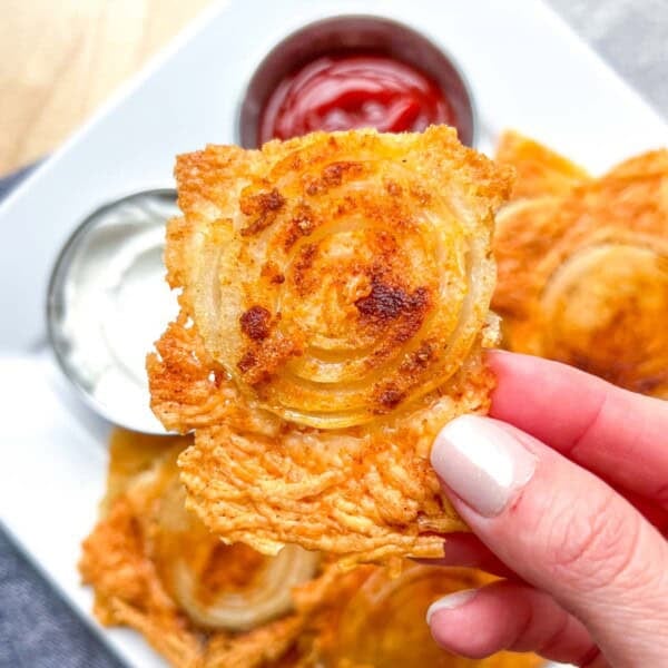 hand holding a crispy onion ring chips.