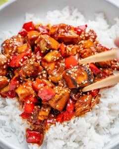 Wooden chop sticks held over chicken and rice.