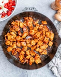Cooked chicken cubes in a skillet.