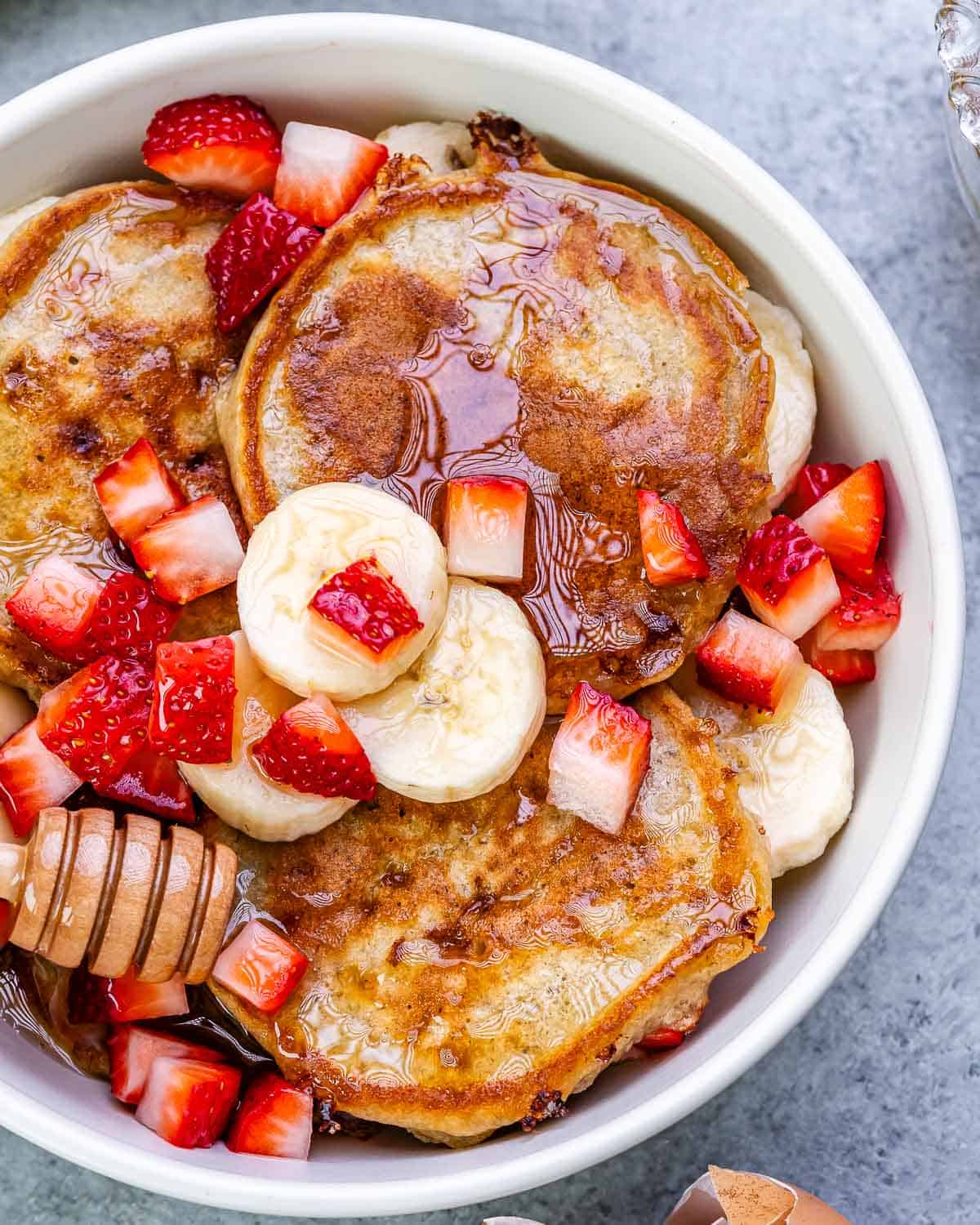 pancakes in a bowl with chopped strawberries and bananas. 