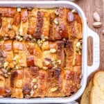 French toast casserole in a dish, topped with chopped pistachios.