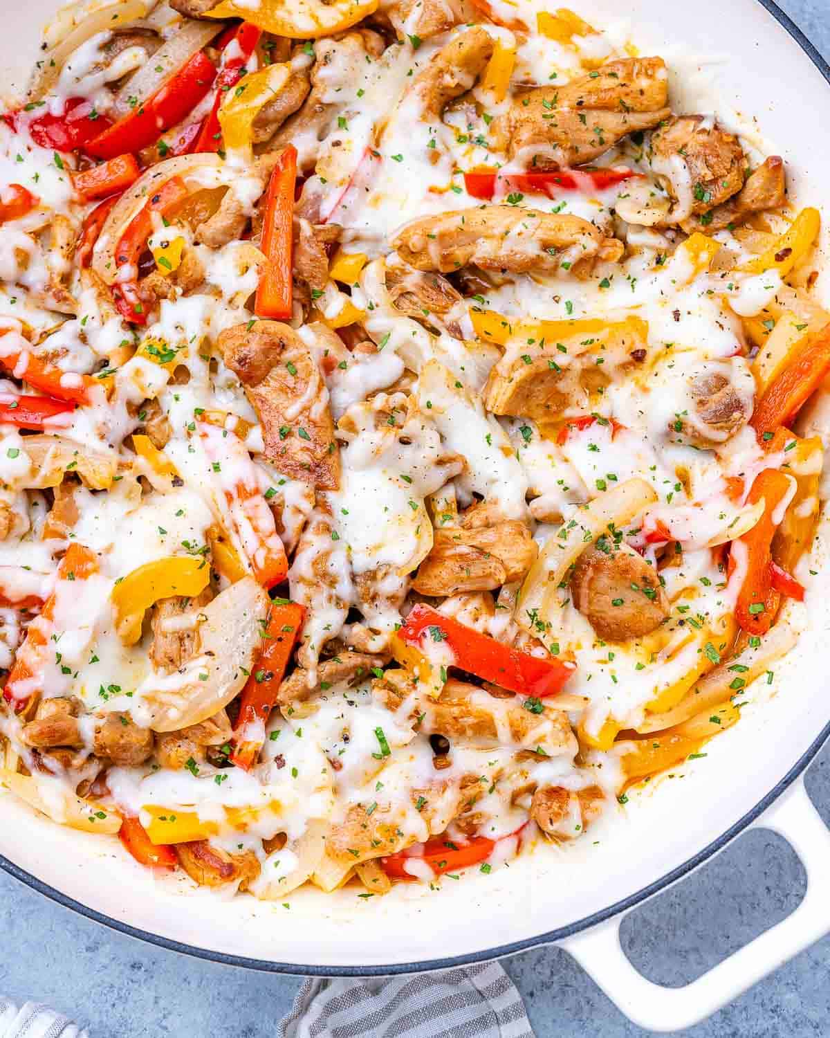 Chicken Philly Cheesesteak skillet topped with gooey melted mozzarella, sliced peppers, onions, and seasoned chicken.