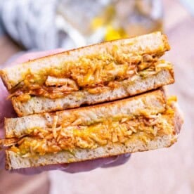 Hand holding chicken sandwich halves.