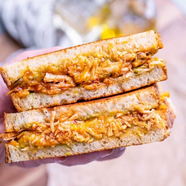 Hand holding chicken sandwich halves.