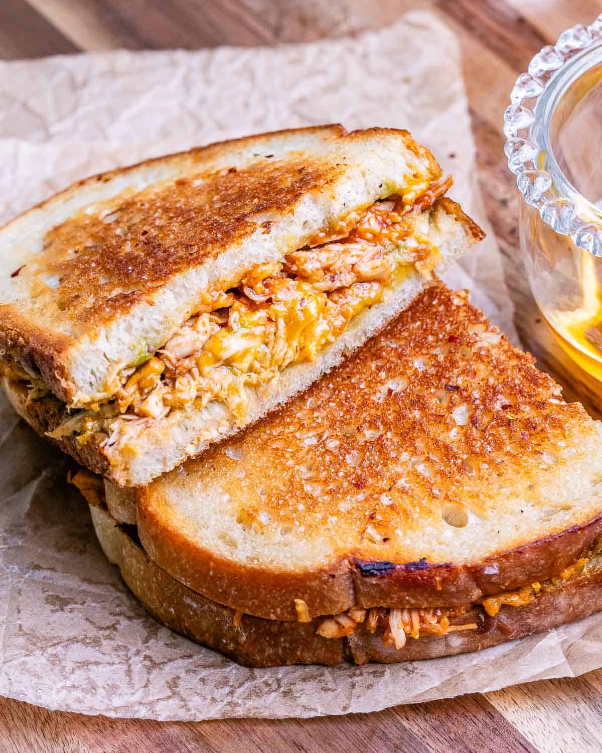 A toasted sandwich cut in half and laying on top of each other.