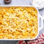 Close-up of a portion of mac and cheese being served from the baking dish.