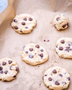 A few cookies spaced out on parchment, slightly cooled with a soft, pillowy appearance.