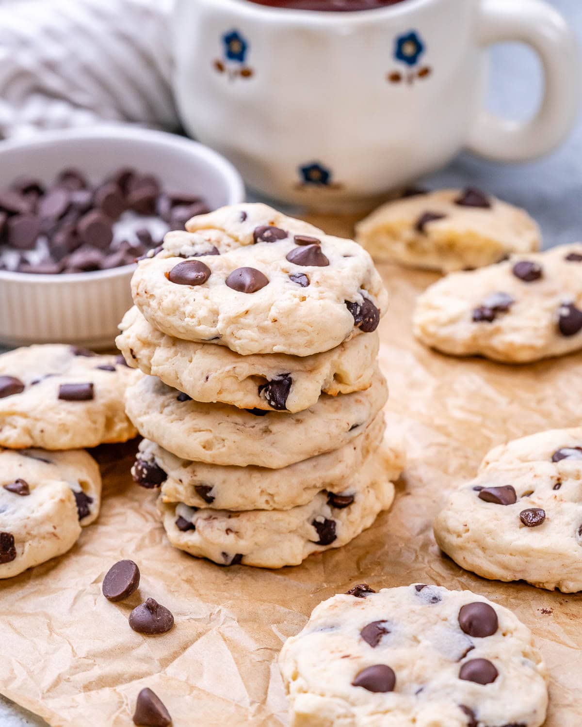 Freshly baked cookies stacked on top of each other with a soft, cakey texture and visible chips.