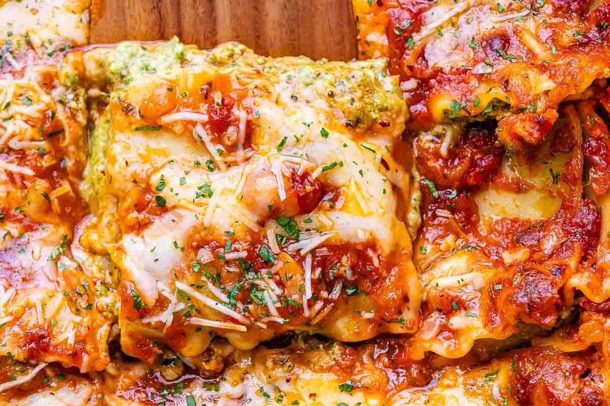spoon grabbing a slice of cottage cheese lasagna from a dish.