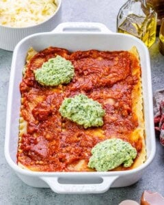layering cottage cheese sauce with marinara and lasagna sheets in a baking dish