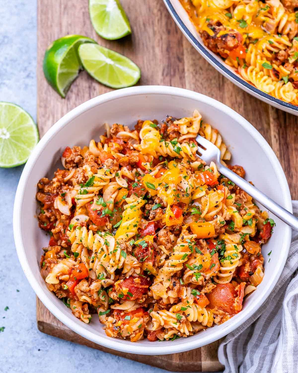 Portion of the cooked pasta served in a bowl, with lime wedges on the side for optional garnish.