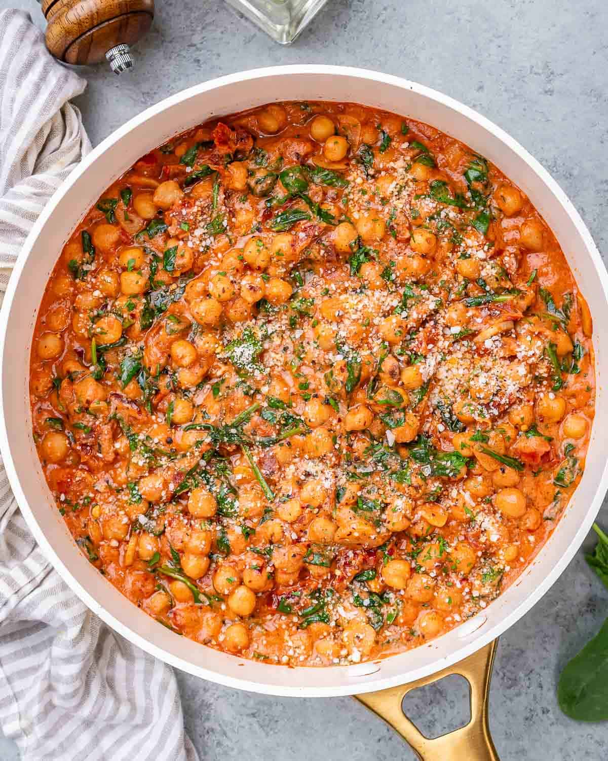 Overhead view of chickpeas simmering in a rich tomato and coconut cream sauce.