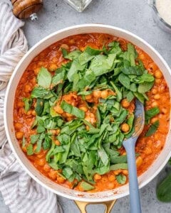 Fresh chopped spinach added into simmering chickpeas and sauce.