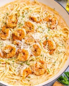 Overhead view of shrimp and pasta garnished with grated parmesan.