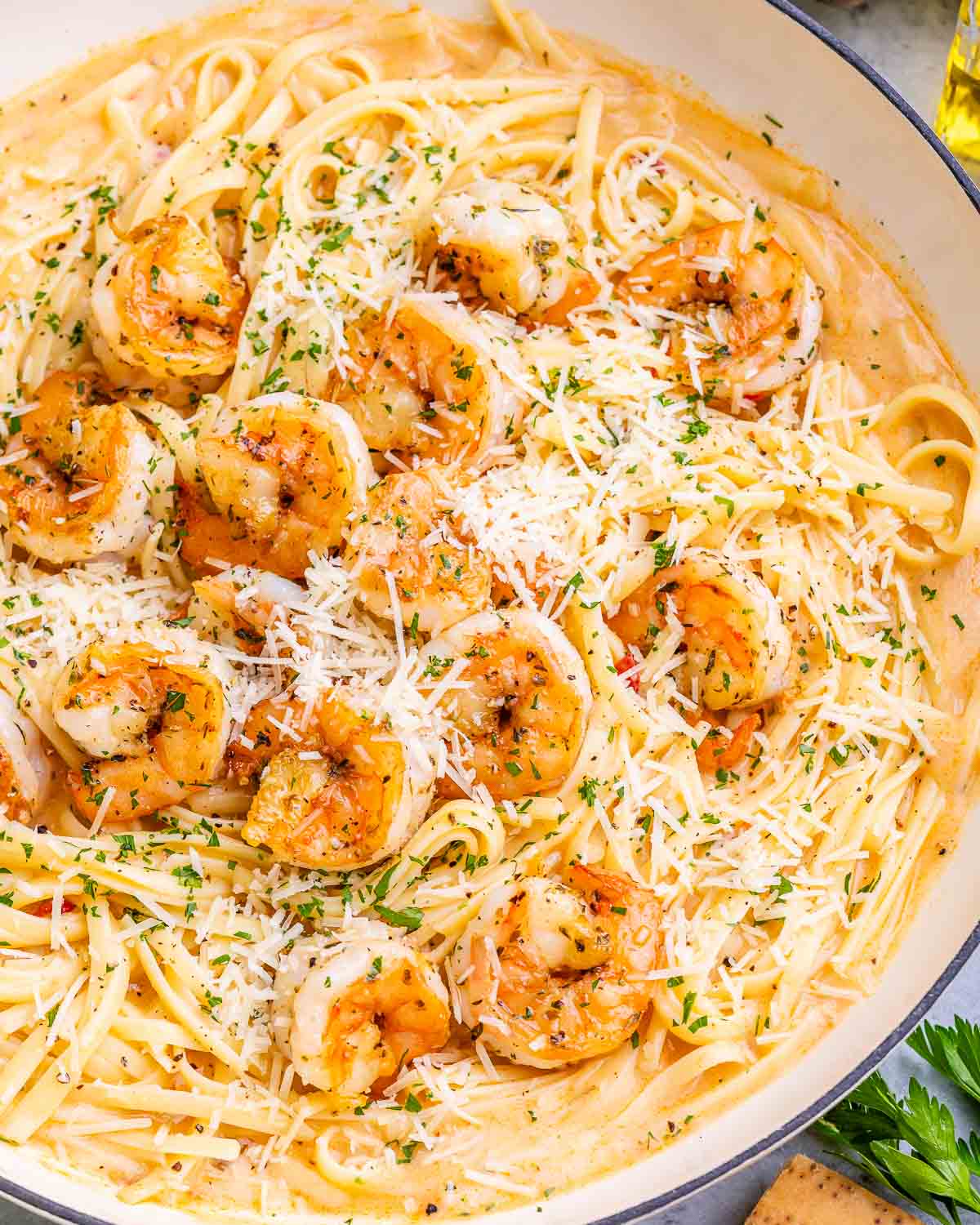 Overhead view of shrimp and pasta garnished with grated parmesan.