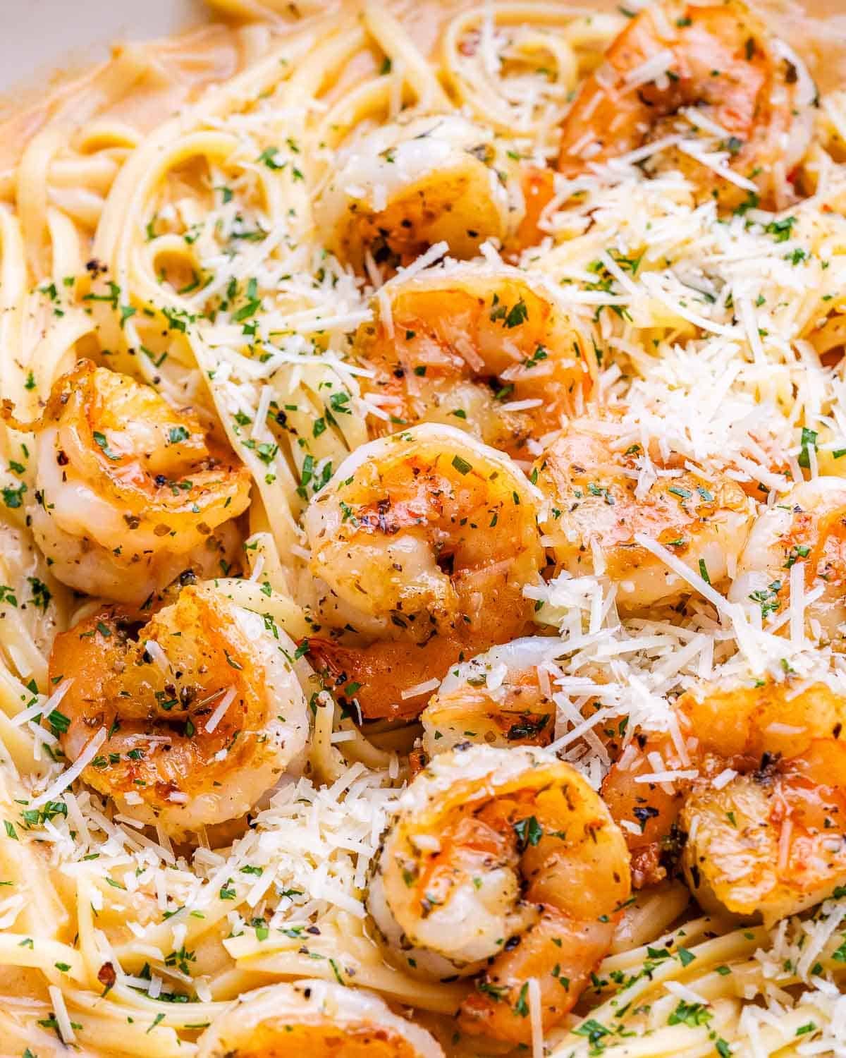 Close-up of the creamy shrimp pasta in the skillet, highlighting the herbs and sauce.