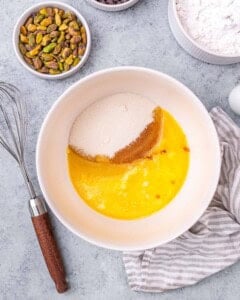 A mixing bowl with melted butter, granulated sugar, and vanilla extract before mixing.