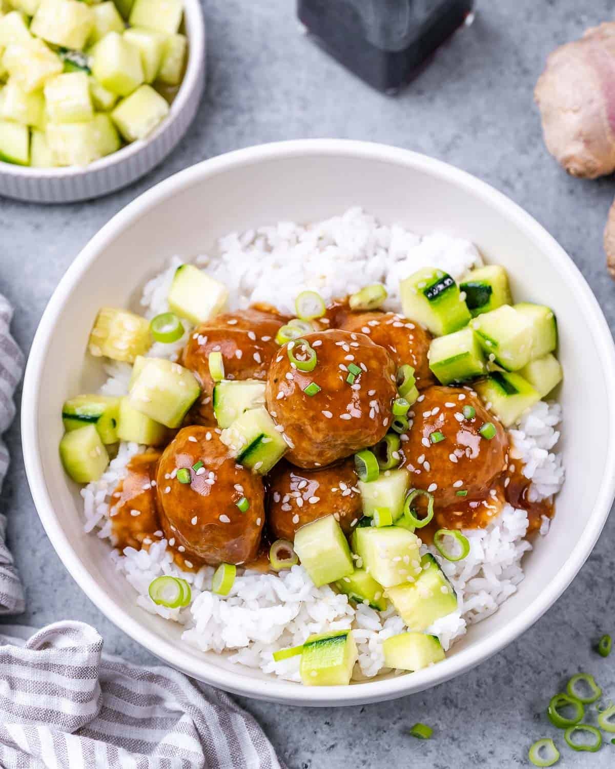 Meatballs over rice, topped with chopped cucumber.