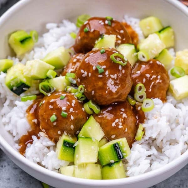 meatballs over rice, topped with chopped cucumber.