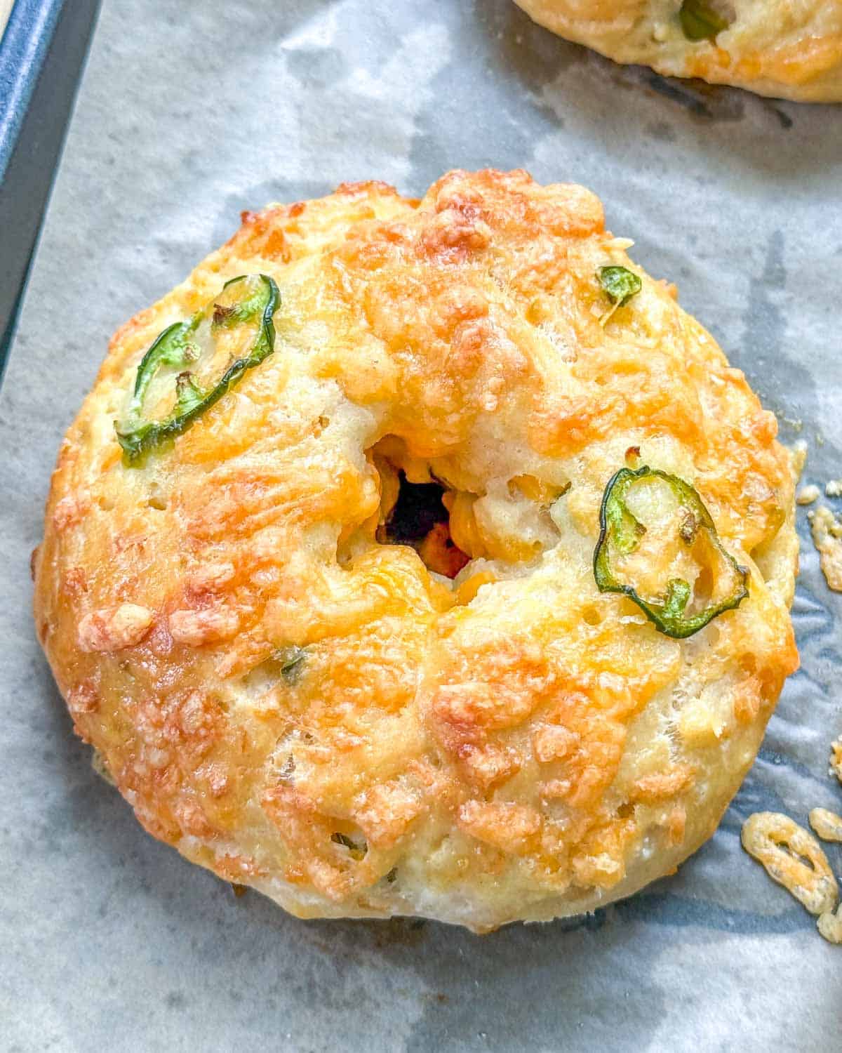 a single baked bagel on a sheet pan. 