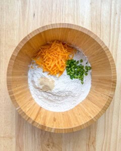 a bowl with flour, cheddar jalapeno and garlic powder.