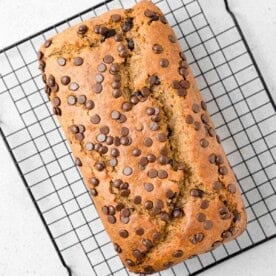 Banana bread with chocolate chips on a wire rack.