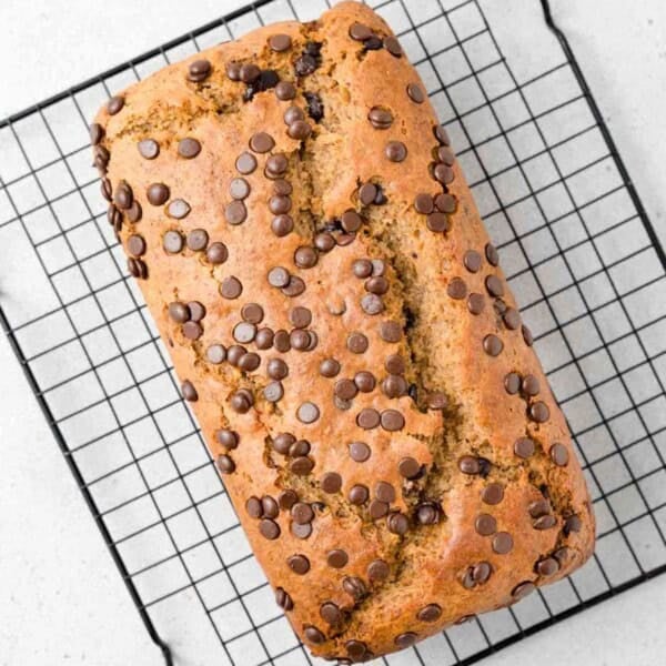 Banana bread with chocolate chips on a wire rack.