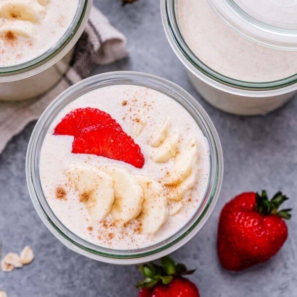 blended oats in a jar topped with sliced bananas and strawberries.